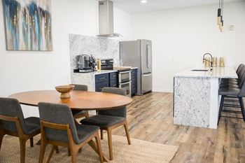 A modern kitchen with a dining table and chairs.